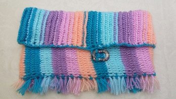 Loop in Pastellfarben. Als Verschluss für die Krempe dient ein Teil eines ausgemusterten Ohrrings.