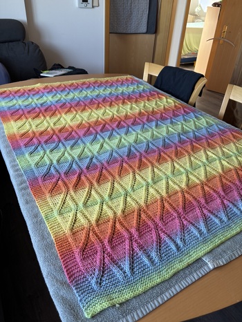 Ich habe Farbverlaufswolle genommen und die Decke etwas größer gestrickt. Sie ist ca. 80cm x 120cm geworden. Sieht wunderschön aus, kinderleicht zu stricken und hat Spaß gemacht. Auf dem Foto liegt zu nach dem Wässern zum trocknen aus.