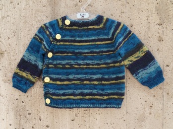 Ich habe das Schlüttli diesmal in Gr. 62 nach der Anleitung gestrickt,
jedoch am Anfang ein paar Veränderungen gemacht.
Ich habe 30  Maschen weniger angeschlagen als angegeben, das Bündchen gestrickt und dabei in der letzten Bündchenreihe diese 30 Maschen gleichmäßig verteilt zugenommen, damit für die Aufteilung vor dem Raglan wieder genug Maschen auf der Nadel sind.
So bekommt man einen etwas engeren Halsausschnitt mit einem Umfang von ca.  23-24 cm.
Außerdem habe ich im Körperabschnitt nur 2 Knopflöcher anstelle der vorgeschlagenen 3 gearbeitet.
Die Wolle ist von Fischer-Wolle: ,,Corina, superwash