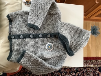 Hab die Jacke für mein erstes Enkerl gestrickt und bin mit der Anleitung recht gut klar gekommen.
Ich mach jedoch nie die Maschenproben und ändere die Anzahl ein wenig nach Gefühl. 😉
Ein schönes Stück, das bereits mehrfach bewundert wurde.