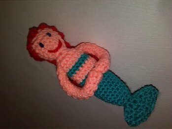 Meine kleine Meerjungfrau ist eine Arielle! Ich habe ein paar Haare mehr daran geknüpft und zu einem Zopf geflochten. Auch das Gesicht hab eich ein bißchen anders gemacht. Ohne Ringschlüssel ist es ein ideales kleines Spielzeug, das in die Hand passt. Danke für diese schöne Anleitung!