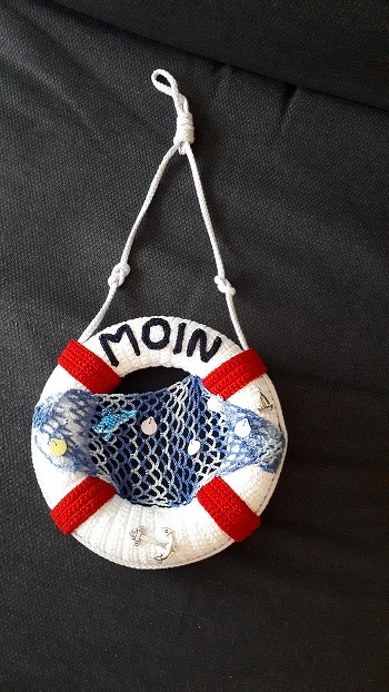 lieben herzlichen Dank für die tolle Anleitung dieser Maritim-Deko. Alles super erklärt, und ich hatte so einen riesen Spaß dabei beim Nachhäkeln. Ging auch relativ flott.
Allerdings hatte ich einen komplett runden Styropor-Ring, und habe die Maschen entsprechend angepasst. Hat problemlos funktioniert dank der einfachen Anleitung.
Was meint ihr, soll ich das so lassen, oder noch einen kleinen Matrosen dazu setzen? oder wirkt das dann so überfüllt?