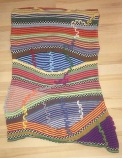 Ich war sofort schockverliebt in diese Tunika. Die Anleitung ist sehr gut und Schritt für Schritt erklärt, ich habe natürlich sofort angefangen, sie nachzuarbeiten. Ich hab die Anleitung modifiziert und im Oberteil weiter Streifen gestrickt und nicht gehäkelt. Dadurch kann ich sie, wenn es wärmer ist, auch ohne T-Shirt oder Blusen tragen.
Durch das Spielen mit den Farben konnte ich meine Reste schön verarbeiten, habe mir nur 3 Farben nachgekauft. Es hat riesigen Spaß gemacht :-))