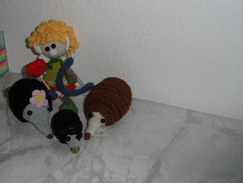 Igelfamilie und der Amor mit Pfeil und Bogen.