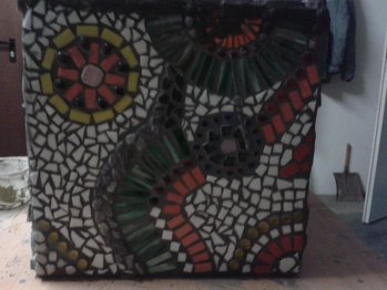 Fliesenmosaik,
ein Würfel aus Holz beklebt mit Fliesen
hier sieht man eine der vier verschiedenen Seiten