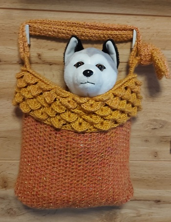 Aus dem Restgarn Diablo Glitter vom Mantel habe ich zusammen mit Twister diese Tasche gehäkelt. Den Riemen kann man auch einfach anknoten, dann ist er länger. Am oberen Rand findet sich das Drachenschuppenmuster vom Mantel wieder. Die Tasche an sich ist mit halben Stäbchen gearbeitet und hat einen doppelten Boden, in den zur Stabilität ein dickere Kunststoffolie (wäre sonst im Müll gelandet) eingelegt ist.