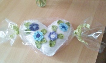 Dieses Herz ist einfach wunderschön. Die Anleitung ist so klasse und leicht aufgebaut und zu verstehen, dass es mir als Anfängerin sogar gelungen ist, wie man sehen kann, Ich kann nur nicht so schnell häkeln aber es ist doch fertig geworden. Von den Blumen hatte ich weit mehr gehäkelt aber mir gefällt es so mit weniger Blumen besser, sieht etwas aufgelockerter aus, Meiner Freundins Lieblingsfarben drauf und als Bonbon verpackt. Bin richtig stolz auf mich - aber nur, weil die Beschreibung samt Bilder so wunderbar verständlich erklärt sind.