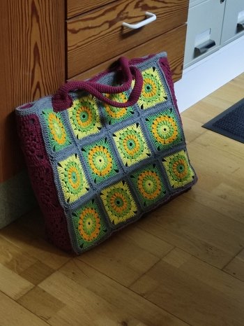 Hallo,
hab die Tasche nach den Wunschfarben einer Bekannten gehäkelt. An der Seite habe ich mit dem Weinrot einfach einfarbig drei Grannys gehäkelt wie die bunten, so hatte ich die Gleiche Höhe und Breite wie die Bunten. Nur unten habe ich die festen Maschen gemacht. Innen drin habe ich Vlieseline Style-Vil und Stoff genommen, damit die Tasche auch mal waschen kann, denn Filz ist oft nicht waschbar und formstabil. So brauche ich mir da keine Gedanken machen. Unten habe ich noch Taschenfüsse angebracht, damit die Tasche nicht immer direkt am Boden steht. Hat Spaß gemacht.