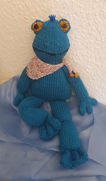 Die „richtige“ Wolle ist nicht mehr erhältlich. Mein Frosch ist mit dünnerer Wolle gestrickt. Die Hände habe ich verändert.