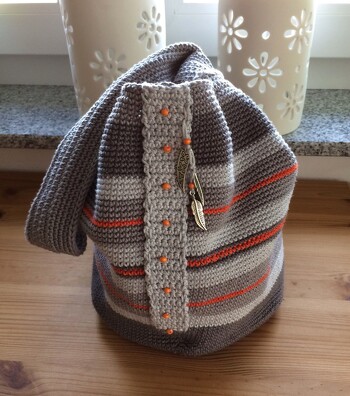 Diesen japanischen Knotenbeutel fand ich interessant und mußte ihn einfach nacharbeiten. Allerdings die Übergänge der Farben sind mir nicht so gut gelungen. Erst habe ich nach Anleitung gearbeitet, dann immer in Runden gehäkelt, beides war nicht optimal. Habe es dann später kaschiert mit Häkelstreifen und Perlchen aufgenäht. Und auch am Träger und der Schlaufe hatte ich Schwierigkeiten, ich habe zwar nach Anleitung gearbeitet, es ist aber nicht so schön geworden. da habe ich dann ebenfalls kaschiert. Aber im großen und ganzen ist mir der Knotenbeutel doch ganz gut gelungen.
