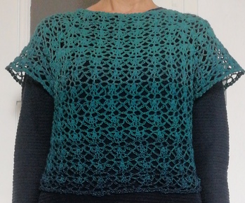 Wenn man das Muster einmal verstanden hat, häkelt es sich auch auswendig. :-).  Die Beschreibung, wie man von der Raglanpasse zum Bauchteil kommt, kann man dann aus dem Zusammhang verstehen. Ich habe einfach mit Maschenmarkierern unter den Armen das Teil zusammengefasst und anprobiert, und mehrfach gedreht, um zu sehen wie es am besten passte. Bin sehr zufrieden. Das Garn für das nächste Teil liegt schon bereit.