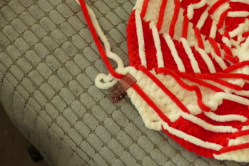 Bei größeren Kissen und dicker Wolle kann man den Faden mit einer Klammer fixieren.