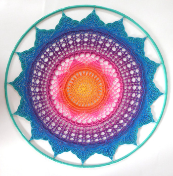 Tolle Anleitung! Gut zum nachhäkeln!
Ich habe das Mandala in einen Metrallring mit 75cm Durchmesser eingehäkelt.