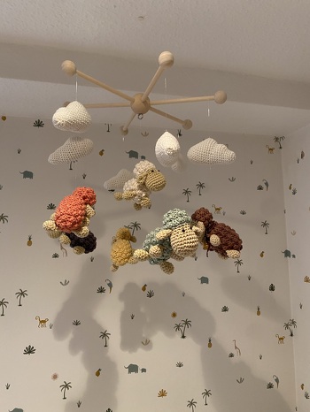 Die Anleitung für das Schäfchen-Mobile von „Zwergerlstrick“ war mein erstes Projekt, welches ich als Einzelanleitung im Bereich Häkeln erworben habe. Im Gegensatz zu Anleitungen aus Heftchen oder Büchern war ich sehr positiv überrascht von der sehr gut im Detail beschriebenen Anleitung. Dieses Mobile hatte sich meine Tochter zur Geburt ihres ersten Söhnchens ausgesucht, was zur Folge hatte, dass sich meine Schwiegertochter auch ein Mobile für ihren Nachwuchs wünschte und ich ihr das Mobile mit den Regentropfen und dem Regenbogen derselben Designerin gehäkelt habe.