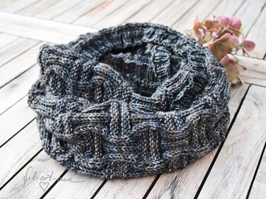 Grey hand-knit basket-weave cowl on whitewashed wooden planks