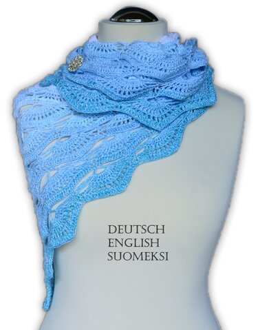 Light blue crochet triangle shawl with lace pattern and scalloped edge pinned with a brooch on a mannequin