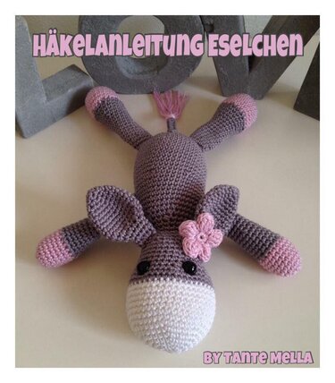 Grau-rosa gehäkeltes Esel-Amigurumi Detailansicht mit weißer Schnauze und Blüte
