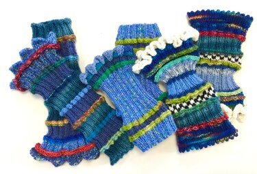Gestrickte Armstulpen in Blau-, Grün- und Rottönen mit Streifen und Rüschen