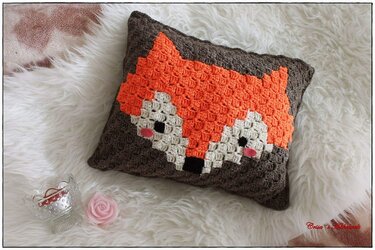 Pixelart-ähnliches gehäkeltes Kissen mit Fuchs-Motiv in Orange, Creme und Braun