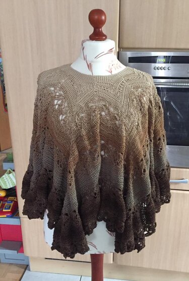 Brauner Häkelponcho mit Farbverlauf und Lochmuster auf Schneiderbüste