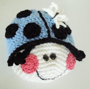 Gehäkelter blauer Marienkäfer-Amigurumi mit schwarzen Punkten und rosa Wangen
