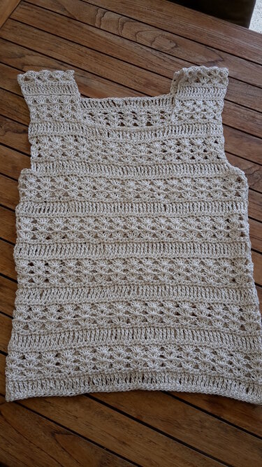 Beiges gehäkeltes Damen-Top mit offenem Lochmuster auf Holz