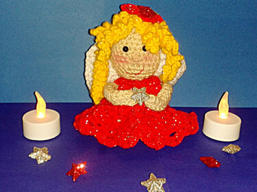 Gehäkeltes Engelchen mit gelben Locken, rotem Kleid und silbernem Stern