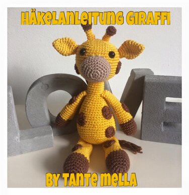 Gehäkelte gelbe Amigurumi-Giraffe mit braunen Flecken vor hellem Hintergrund