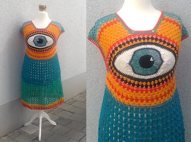 Handgehäkeltes, buntes Damenkleid mit großem Augenmotiv und Granny-Square-Muster auf Schneiderpuppe