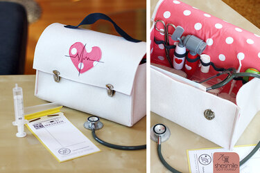 Weißer genähter Spiel-Arztkoffer mit gepunktetem Innenfutter, elastischen Schlaufen und Spielutensilien