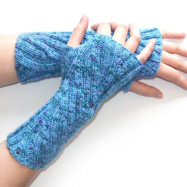 Gestrickte blaue fingerlose Armstulpen mit Strukturmuster an Händen