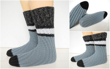 Detailansicht gestrickter grauer Socken mit schwarzer Zehenkappe und weißem Streifen