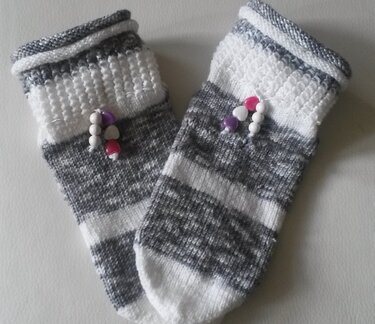 Grau-weiß gestreifte, handgestrickte Damensocken mit Perlen am Bündchen.