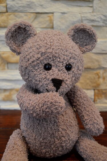 Gehäkelter flauschiger Amigurumi-Teddybär in Taupe, sitzend