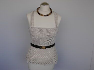Ecrufarbenes gestricktes Top auf Schneiderpuppe mit eckigem Ausschnitt, breiten Trägern, netzartigem Saum, schwarzem Gürtel und Halskette