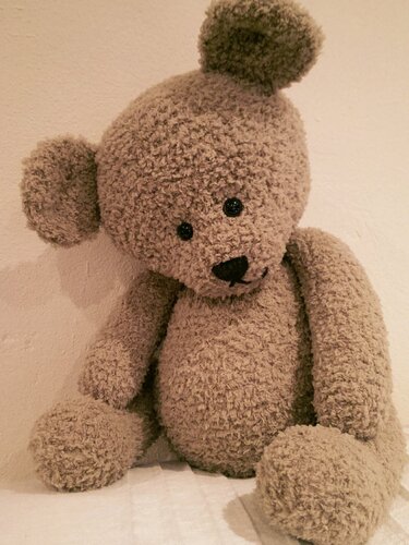 Beiger flauschiger gehäkelter Teddybär mit schwarzen Augen und Nase