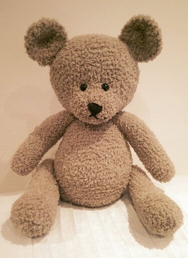 Sitzender flauschiger brauner Häkel-Teddybär