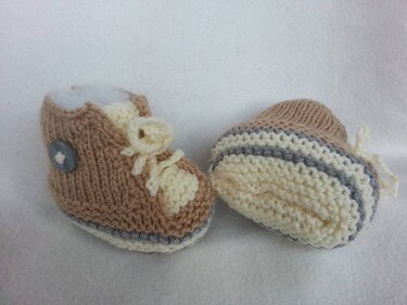 Zweifarbige gestrickte Babyschuhe mit gestreifter Sohle, Zierschnürung und Knopf