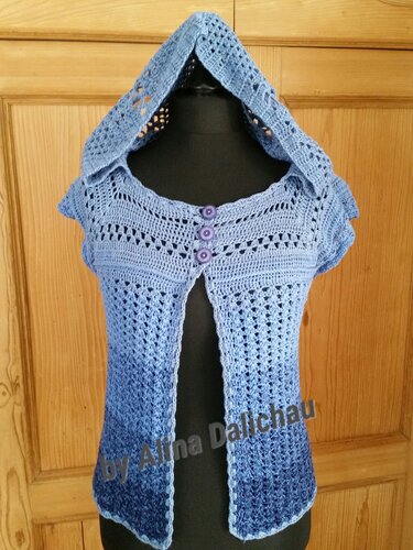 Gehäkelte Damen-Kapuzenweste in Blau mit Farbverlauf, kurzen Ärmeln und drei Zierknöpfen auf einer Schneiderpuppe