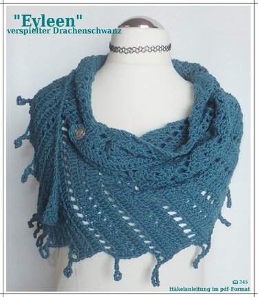 Petrolfarbener, gehäkelter Drachenschwanz-Schal auf Schaufensterpuppe mit Knopf und Fransen.