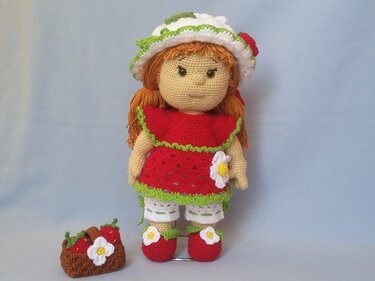 Gehäkelte Amigurumi-Puppe mit rotem Kleid, weißem Hut und Korb mit Erdbeeren