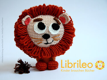 Gehäkelter Amigurumi-Löwe mit buschiger rostroter Mähne auf weißem Hintergrund
