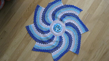 Achtzackiges gehäkeltes Deckchen mit blauem Spiralmuster und Rosettenmitte, Muster klar sichtbar