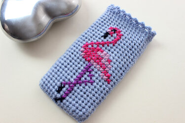 Hellblauer, handgehäkelter Utensilo mit pink-violettem Flamingo-Motiv
