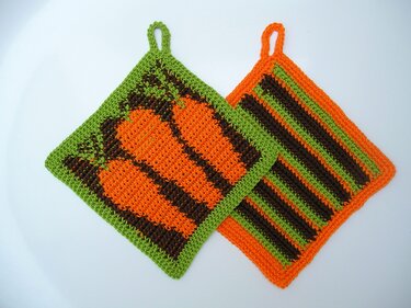 Zwei gehäkelte quadratische Topflappen, einer mit Karottenmotiv, einer gestreift