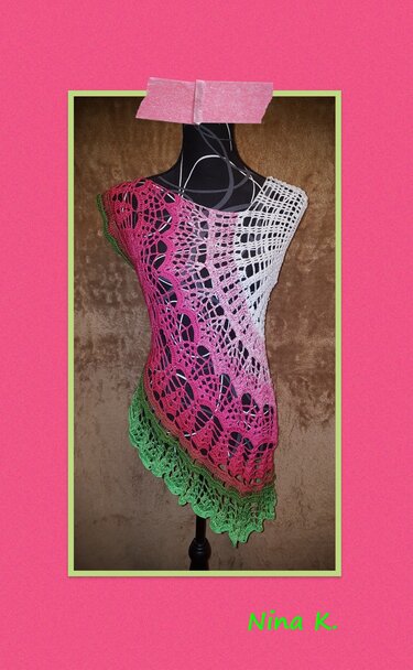 Gehäkelte Damen-Tunika auf schwarzer Schaufensterpuppe, Farbverlauf Weiß-Pink-Grün mit filigranem Lochmuster und asymmetrischem Saum.