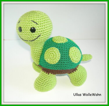 Gehäkelte grüne Schildkröte Amigurumi mit Punkten auf weißem Hintergrund