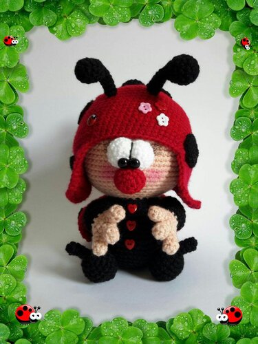 Nahaufnahme eines gehäkelten Marienkäfer-Amigurumi mit roter Mütze, schwarzen Punkten und herzförmigen Knöpfen