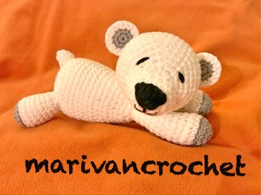 Detailansicht von Maschen, Ohren und Pfoten eines weißen gehäkelten Amigurumi-Teddys