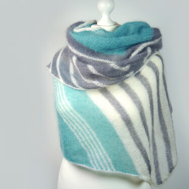 Rectangular knitted shawl with teal, gray and white stripes on a mannequin